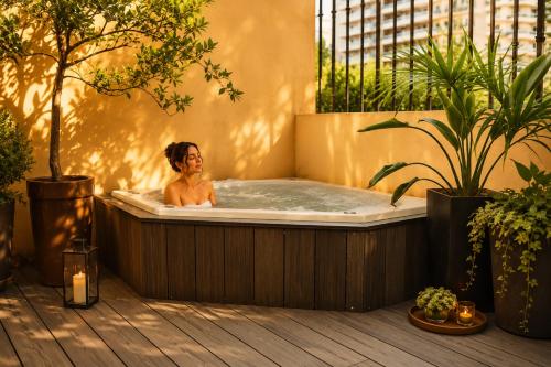 a man in a jacuzzi tub in a backyard at Miravida Soho Hotel & Wine Bar in Buenos Aires