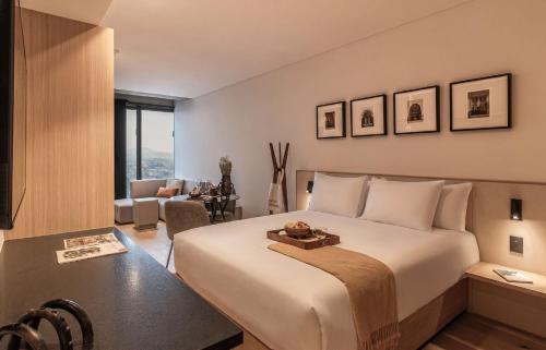 a bedroom with a large bed and a living room at University Tower by Kukun Apartments in Mexico City