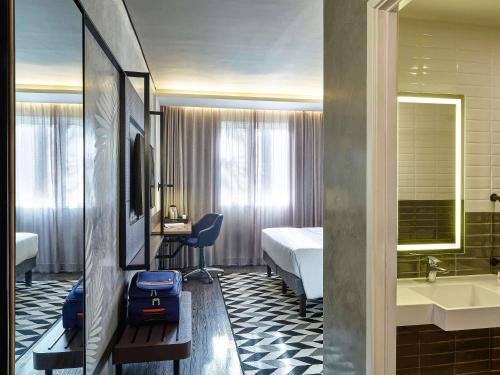 a hotel room with a bedroom with a bed and a bathroom at Novotel Sao Jose dos Campos in São José dos Campos