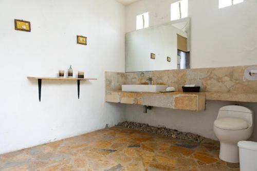 ein Badezimmer mit Toilette, Waschbecken und Spiegel in der Unterkunft Hotel Isla Real in Tierra Bomba