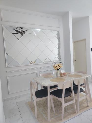 a white dining room with a table and chairs at Sky13 Homestay in Kota Bharu
