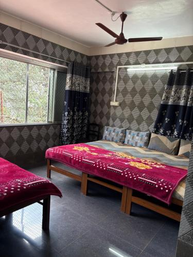 a bedroom with a bed with a red blanket at ROGHAY COTTAGE in Matheran