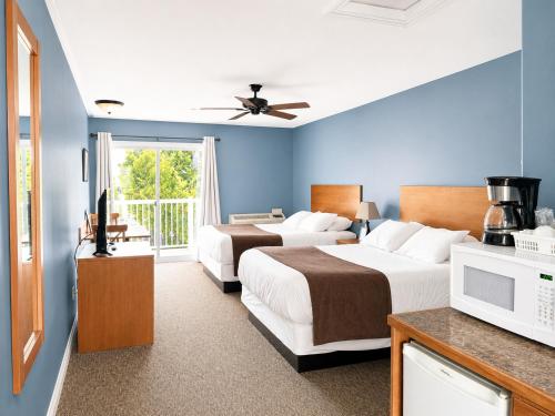 two beds in a room with blue walls at Escarpment Heights Motel in Tobermory