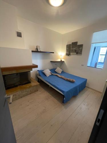 a bedroom with a blue bed and a fireplace at Casa Estense in Lido degli Estensi