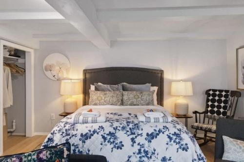 a bedroom with a large bed and two chairs at Private Oceanfront Suite Hot Tub & Fireplace in Lunenburg