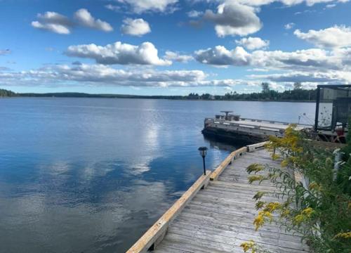a dock on a body of water with clouds in the sky at Private Oceanfront Suite Hot Tub & Fireplace in Lunenburg