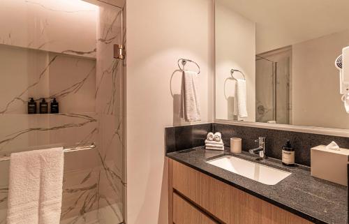 a bathroom with a sink and a shower at University Tower by Kukun Apartments in Mexico City