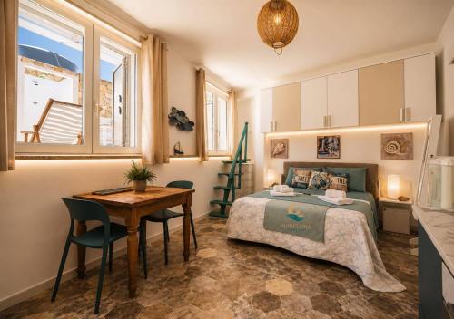 a bedroom with a bed and a table and a desk at Mareluna Luxury Accomodation in Lampedusa