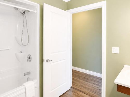 a bathroom with a shower and a white door at Escarpment Heights Motel in Tobermory