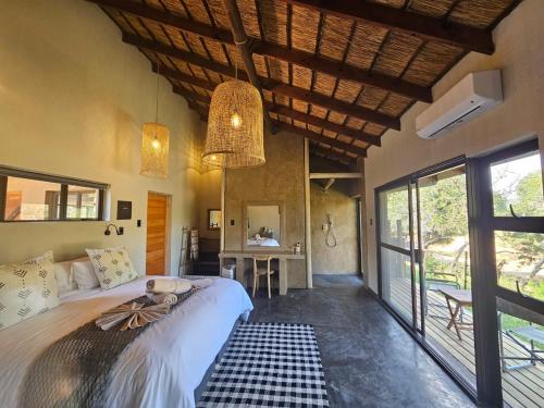 a bedroom with a bed and a large window at Nkinga River Lodge in Balule Game Reserve