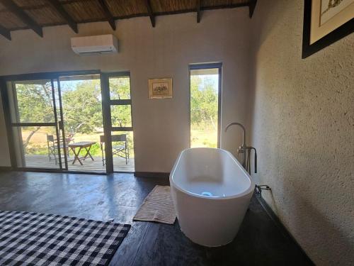 a large bath tub sitting in a room with a door at Nkinga River Lodge in Balule Game Reserve