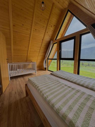 a bedroom with a large window in a log cabin at Vlasic Odmor - Villa Vlasicka Bajka in Vlasic