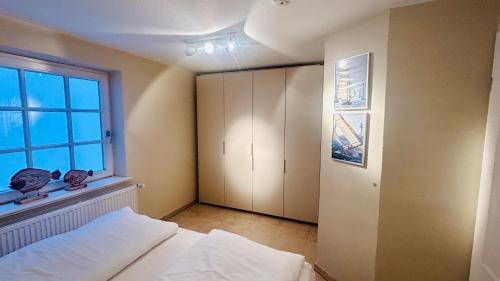 a bedroom with a bed and a window at Heefkant Haus Heefkant, HK 04 in Rantum