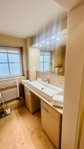a bathroom with a sink and a large mirror at Heefkant Haus Heefkant, HK 04 in Rantum