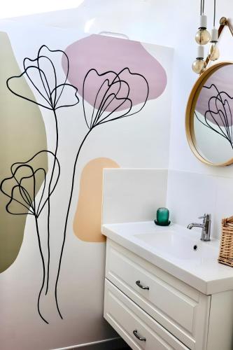 a bathroom with a flower mural on the wall at Gite La Saintonge in Sainte-Gemme