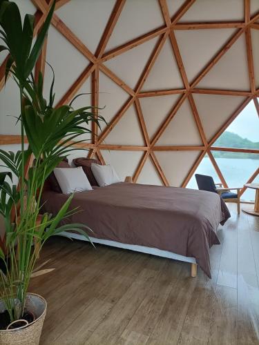 a bedroom with a bed in a large wooden tent at Les Gîtes De Robin'son in Foulcrey