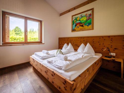 a bedroom with a wooden bed with white pillows at Zattach 57 in Lake Pressegg