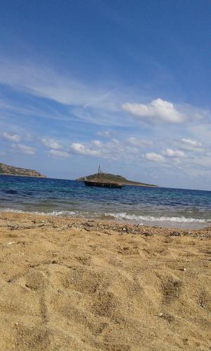 a beach with an island in the water at Appartamenti Il Castellaccio in San Siro