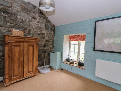 a room with blue walls and a stone wall at Culearn Mill in Lochearnhead
