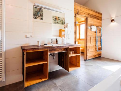 a bathroom with a wooden vanity with a sink at Siwitz 55 in Lake Pressegg