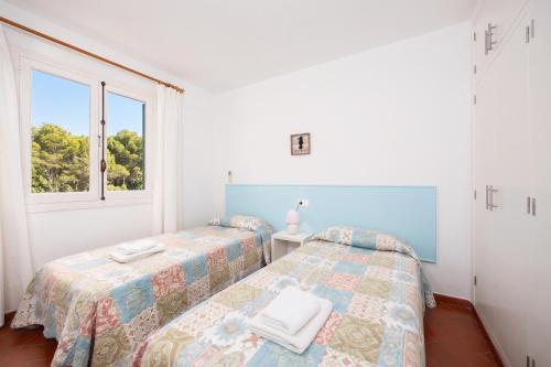 two beds in a room with a window at Villa Trepuco Uno in Punta Prima