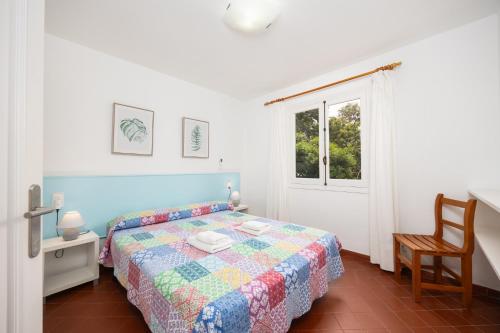 a bedroom with a bed and a chair and a window at Villa Trepuco Dos in Punta Prima