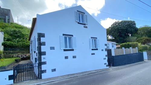 a white house with blue paint on it at Angelic Sea View in Bretanha