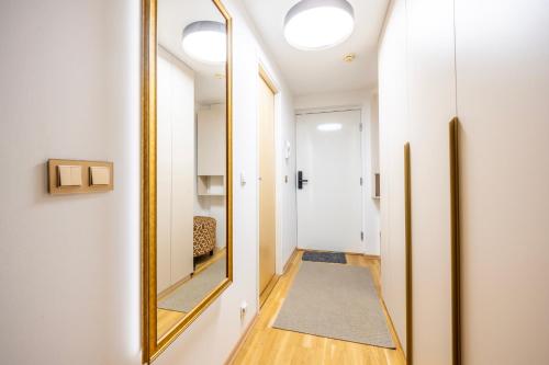 a hallway with a mirror and a rug at Bright Studio in Rotermann Quarter - Noor Apartment in Tallinn