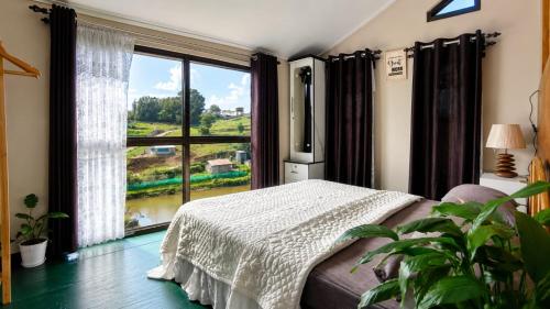 a bedroom with a bed and a large window at Cozy corner Homestay in Mawphlang