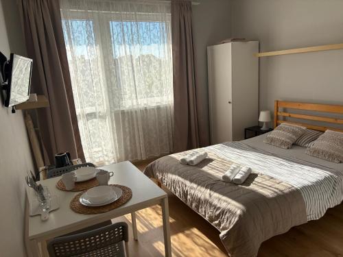 a bedroom with a bed and a table and a window at NIKA Pokoje u Weroniki in Władysławowo