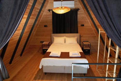 a bedroom with a bed in a room with wooden floors at Eylül Bungalow Kaş in Kaş