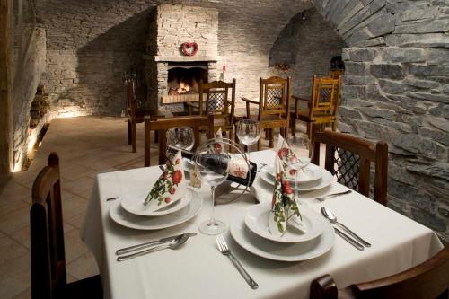 a table with plates and wine glasses and a fireplace at Penzion U Veterána in Slatinice