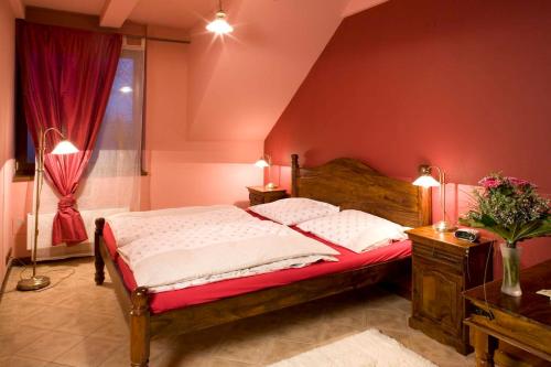 a bedroom with a bed with red walls and a window at Penzion U Veterána in Slatinice