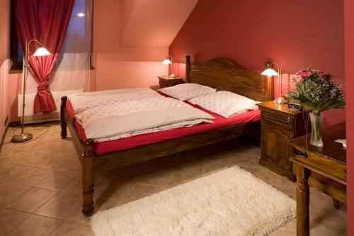 a bedroom with a bed and a table and two lamps at Penzion U Veterána in Slatinice