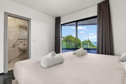 a bedroom with a large bed with two towels on it at Villa Viola in Lovran