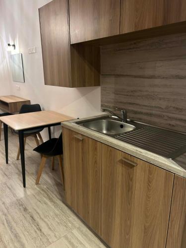 eine Küche mit Spüle und einem Tisch in der Unterkunft Simos Magic Hotel Apts in Ayia Napa