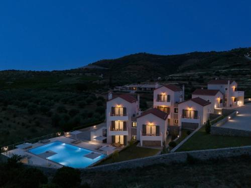 a large house with a swimming pool at night at Anassia Villas in Nafplio
