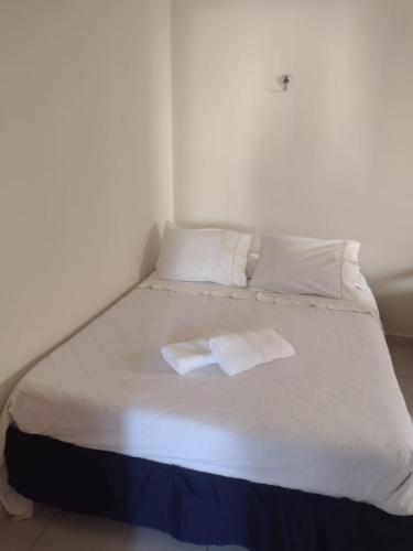 a white bed with two towels on top of it at Hospedaria São Francisco in Cachoeira Paulista