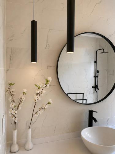 a bathroom with a round mirror and a sink at Casa Ypá in Puerto Libertad