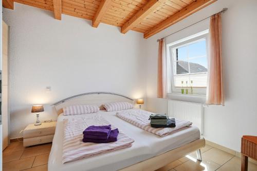 a bedroom with a bed with two bags on it at Friesenperle in Greetsiel