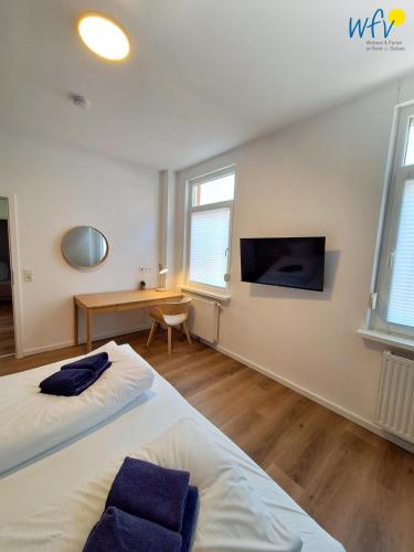 a bedroom with two beds and a desk and a table at Stine's Hus Ferienwohnung 2 in Borkum