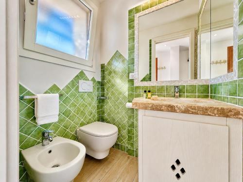 a bathroom with a toilet and a sink and a mirror at Sunset Three Shared Pool 100m from the Beach in Baja Sardinia