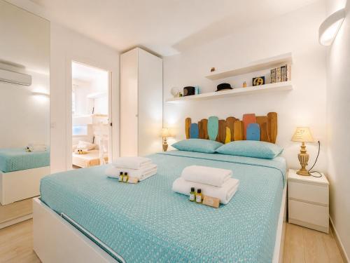 a bedroom with a large bed with two pillows at Sunset Three Shared Pool 100m from the Beach in Baja Sardinia
