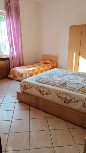 two beds in a room with a tiled floor at Casa Vanda in Orte