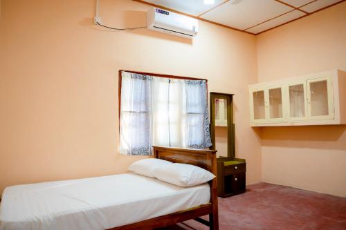 a bedroom with a white bed and a window at Naga Vasa in Jaffna