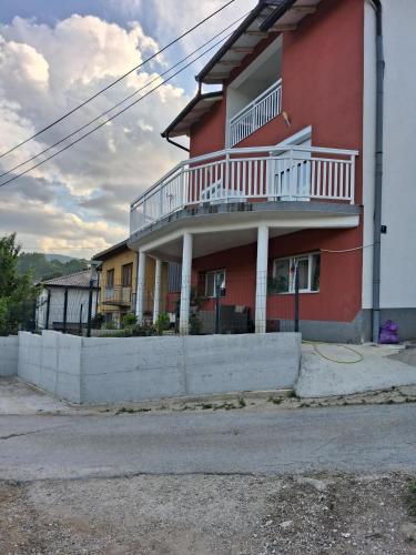 a red building with a balcony on the side of it at Vila jajcegrad in Jajce