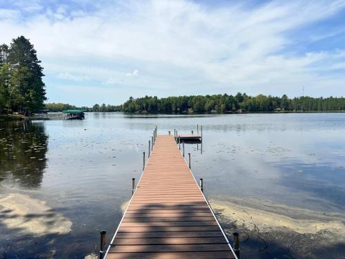 a dock in the middle of a large lake at Towering Pines Cottage in Saint Germain