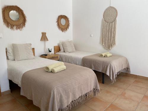 a room with three beds and a mirror on the wall at Brisa de Milfontes in Vila Nova de Milfontes