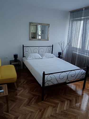 a bedroom with a bed and a mirror on the wall at Studio apartman LUNA in Vinkovci