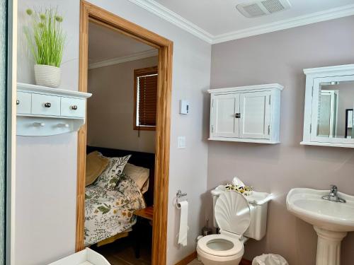 a bathroom with a toilet and a sink and a bed at Loft de la mer in Sainte-Flavie